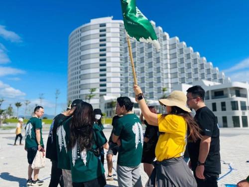 a group of people holding a green flag at Sea Moon Cam Ranh Beach House in Cam Ranh