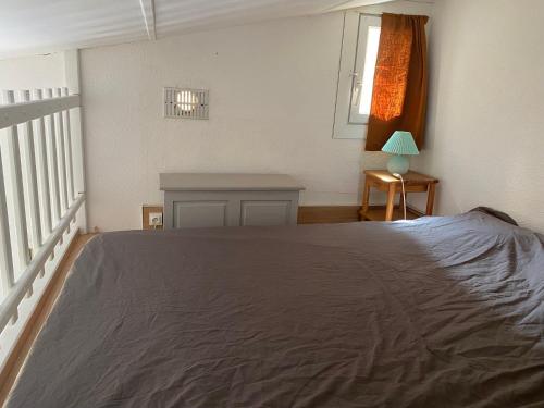 une chambre avec un grand lit et une table dans l'établissement Joli appartement mezzanine avec parking et wifi La Roquille, au Cap d'Agde