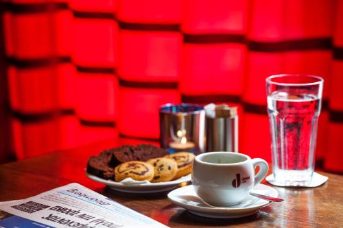 a table with a plate of cookies and a cup of coffee at Egnatia Hotel in Thessaloniki