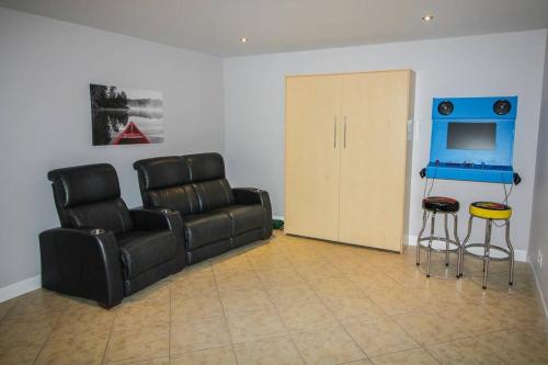 a living room with a couch and a television at Chalet Au petit Édouard (Mont Édouard) in LʼAnse-Saint-Jean