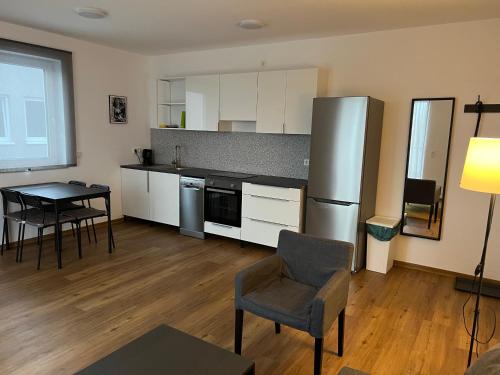 a kitchen with a refrigerator and a table and chairs at ApartHotel Roxheim in Roxheim