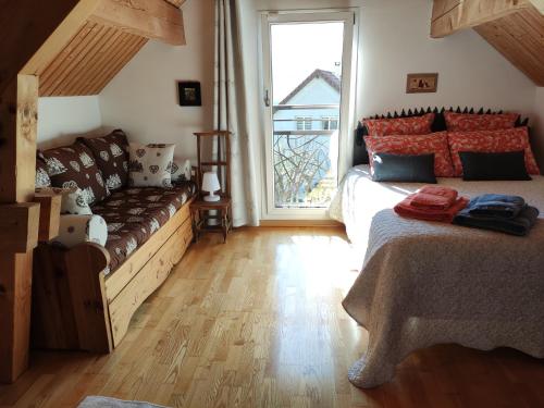 a living room with a couch and a large window at Chambres d'hôtes Au Doubs Murmure in Les Fins