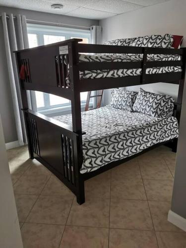 a set of bunk beds in a room at Chalet Au petit Édouard (Mont Édouard) in LʼAnse-Saint-Jean