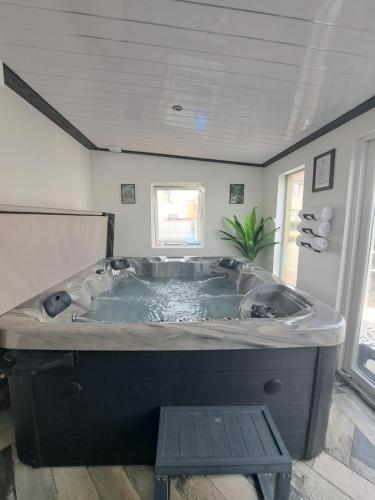 a large bath tub in a bathroom with a table at Family Holiday with Hot tub , Family groups only in Blackpool