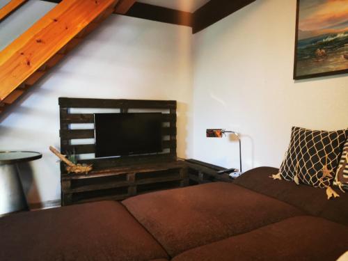 a living room with a couch and a flat screen tv at InselScheune Rügen in Wiek auf Rügen 