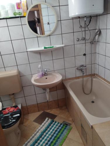 a bathroom with a sink and a tub and a mirror at Gogo. in Kupres