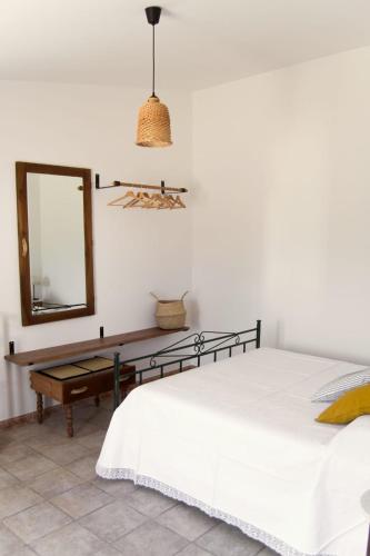 a bedroom with a bed and a mirror and a table at Trulli Cibelis in Noci