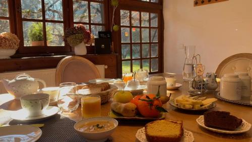 a table with a breakfast of bread and orange juice at Maison d'hôtes La Bageatière - Lac d'Aiguebelette in Lepin-le-Lac
