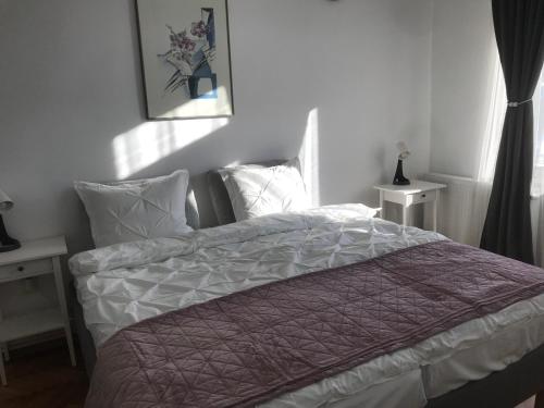 a bedroom with a bed with a purple and white comforter at SONNENSCHEIN in Cîmpulung