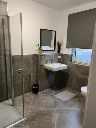 a bathroom with a sink and a shower at ApartHotel Roxheim in Roxheim