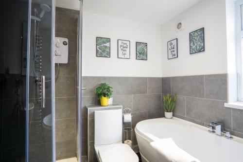 a bathroom with a tub and a toilet and a shower at Air Host and Stay - Cedar House - sleeps 7, parking, 8 mins to city in Liverpool