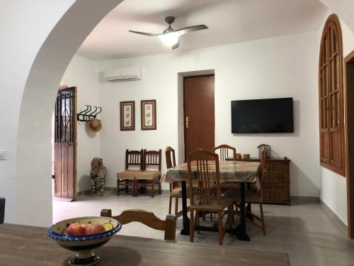 ein Wohnzimmer mit einem Tisch und einem TV in der Unterkunft Cortijo los Garridos - 7 huéspedes in Almería