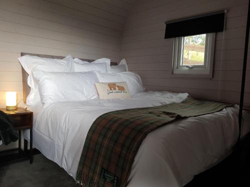 a bedroom with a white bed with a dog pillow on it at Dunbeath Coastal Retreat in Dunbeath