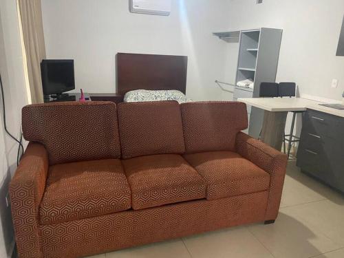 a brown couch in a living room with a table at Loft Hermoso en Guadalupe BBVA in Monterrey