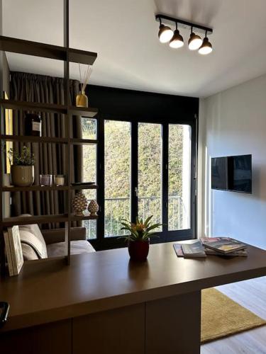 - un salon avec un bureau et une grande fenêtre dans l'établissement Riva 22, à Lugano