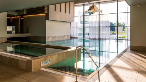 a swimming pool with a glass floor in a building at Maisonette - Golf & Wellness in Oosterhout
