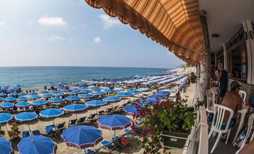 a group of umbrellas and chairs on the beach at Appartamenti In Piazzetta in Deiva Marina