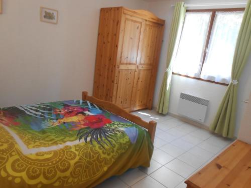 une chambre avec un lit et une armoire en bois dans l'établissement Antilles, à Savines