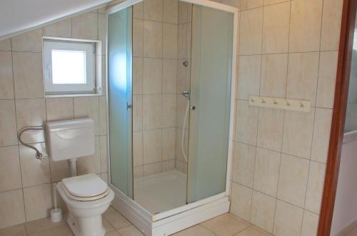 a bathroom with a toilet and a glass shower at Apartments Summer Joy in Novalja
