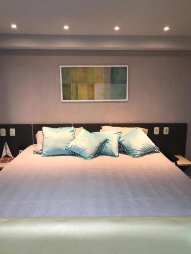 a large bed with blue and white pillows at ALIANÇA TABATINGA Hospedagem Boutique in Conde