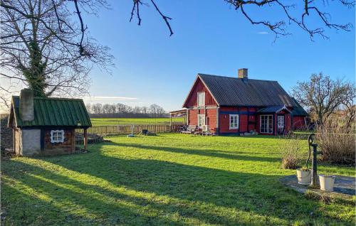 a red house with a green roof in a field at Amazing Home In Visby With Wifi in Visby
