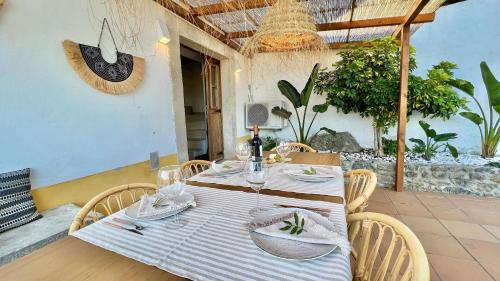 a table with a white table cloth and chairs on a patio at Artisan´s Guest House in Óbidos