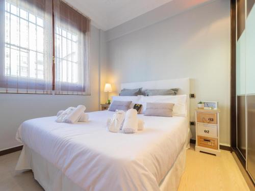 1 dormitorio con 1 cama blanca grande y toallas. en Pozas Accommodation by Next Stop Bilbao, en Bilbao