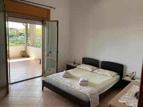 a bedroom with a bed and a sliding glass door at Attico al mare in Badolato