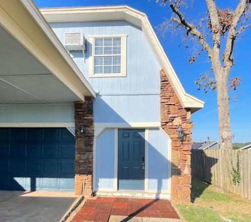 a white house with a blue garage door at Lake House and Studio Book Two places in one 4 bedrooms large driveway and yard in Rogers