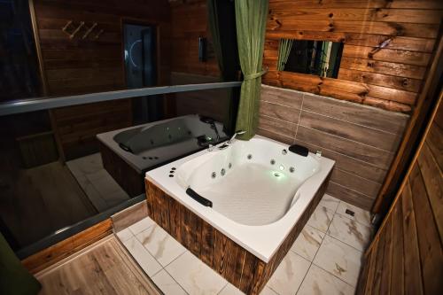 a large bathroom with a tub and a bath tub at Pınar Suit Bungalow in Ardeşen