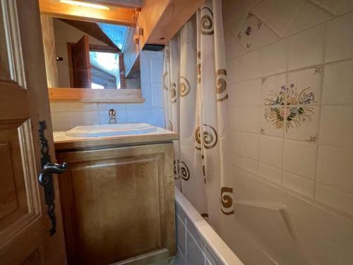 uma casa de banho com um lavatório, uma banheira e um espelho. em Appartement Méribel, 4 pièces, 6 personnes - FR-1-688-49 em Méribel