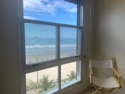 a window in a room with a view of the beach at Apartamento Centro Frente Mar-Mongaguá in Mongaguá