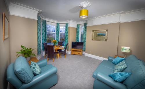 a living room with two blue couches and a table at Spacious 1st Floor Apartment in Keswick
