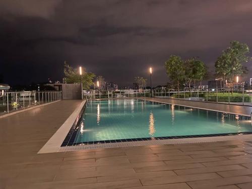ein Schwimmbad in der Nacht mit eingeschalteten Lichtern in der Unterkunft residensi condominium, taman melati, danau kota, gombak in Kuala Lumpur