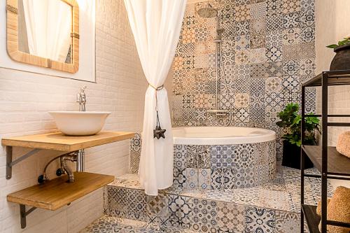 y baño con bañera y lavamanos. en LAZURITE MASPALOMAS Apartamentos Sur Gran Canaria en El Tablero