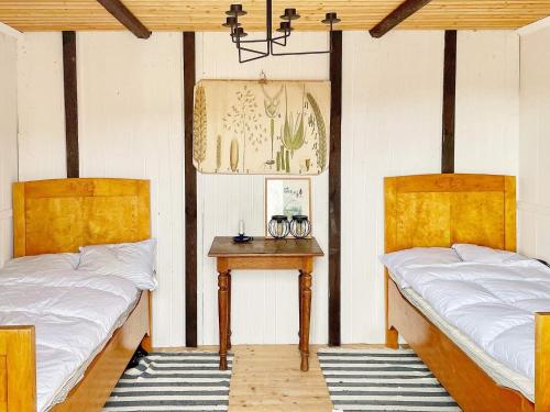 duas camas num quarto com uma mesa entre elas em Holiday home Edsbruk em Edsbruk