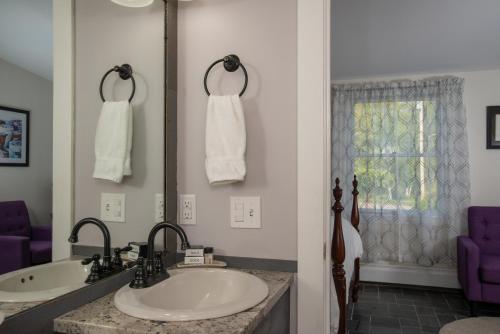 een badkamer met 2 wastafels en een grote spiegel bij The Bradley Inn in New Harbor
