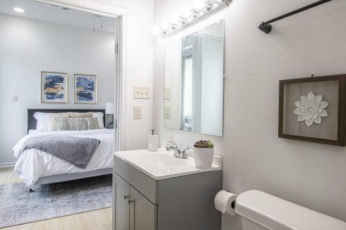 a bathroom with a sink and a mirror and a bed at Luxury NOLA House w 6 Bedrooms in New Orleans
