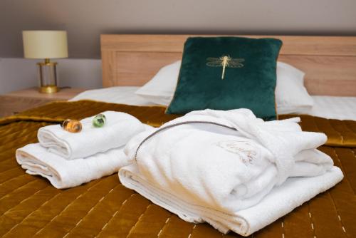 een stapel handdoeken bovenop een bed bij Dom Oleńka- Kaszuby, weekend, wakacje, sauna, jacuzzi, jezioro in Garcz