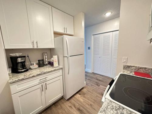eine Küche mit weißen Schränken und einem weißen Kühlschrank in der Unterkunft Cozy 1 bedroom Apartment in Downtown Gadsden, AL in Gadsden