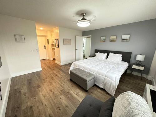 een slaapkamer met een groot wit bed en houten vloeren bij Cozy 1 bedroom Apartment in Downtown Gadsden, AL in Gadsden