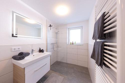 a white bathroom with a sink and a mirror at Der Hochkönigblick in Dienten am Hochkönig