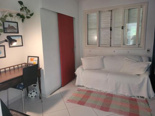 Habitación con cama, escritorio y ventana. en Linda casa no Rio de Janeiro (Itanhangá), en Río de Janeiro