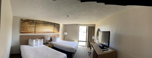 a hotel room with two beds and a flat screen tv at Days Inn by Wyndham Fayetteville-South/I-95 Exit 49 in Fayetteville