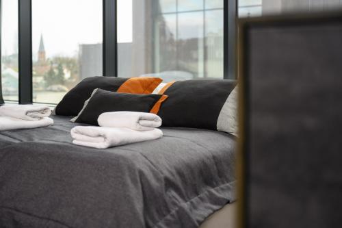 a bed with towels on top of it with a window at Rich Sopot by OneApartments in Sopot