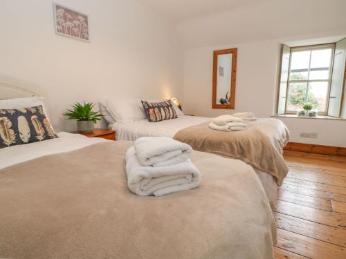 SmeafieldにあるKits Cottageのベッド2台(白いタオル付)が備わる客室です。