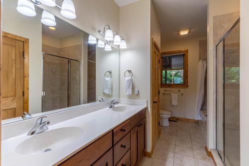 baño con 2 lavabos y espejo grande en Hideaway Mountain en Seven Devils