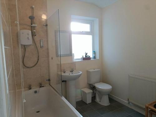 a bathroom with a tub and a toilet and a sink at Bright, Comfortable Home, Convenient for City Centre in Liverpool
