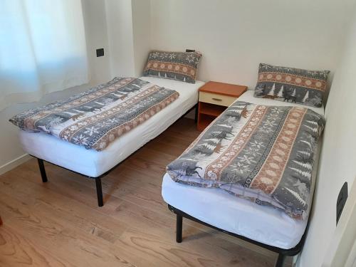 two twin beds in a room with wooden floors at Paragole in Pera