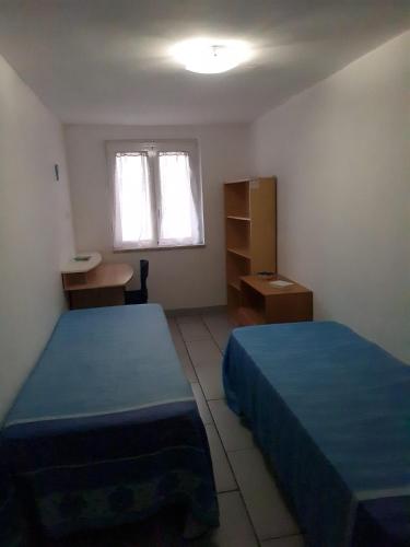 ナポリにあるLovely Glaucus's cottageのベッドルーム1室(ベッド2台、デスク、窓付)